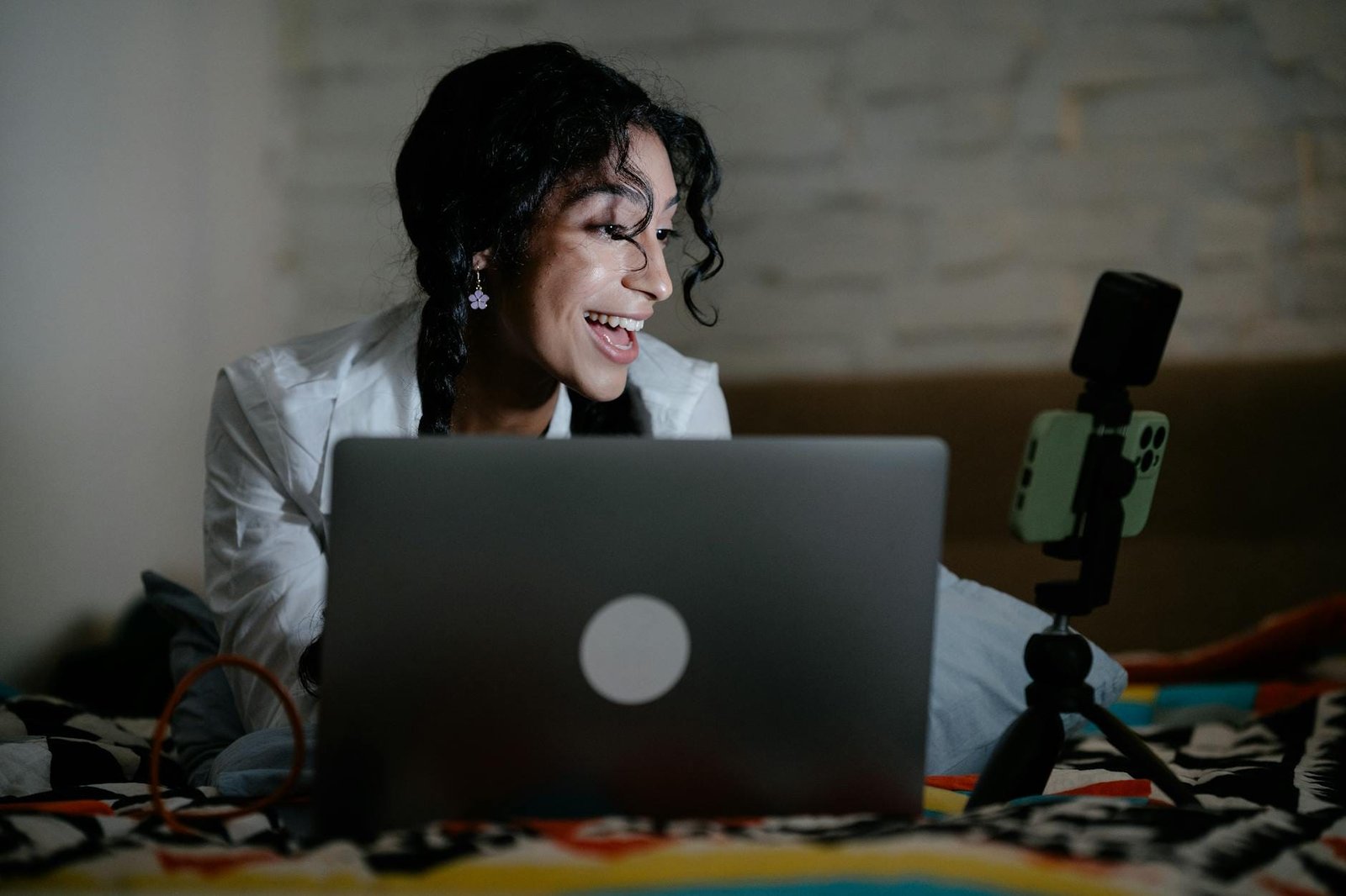Anneau lumineux posé derrière un écran d’ordinateur, sur un bureau, éclairant la personne assise face à la webcam.